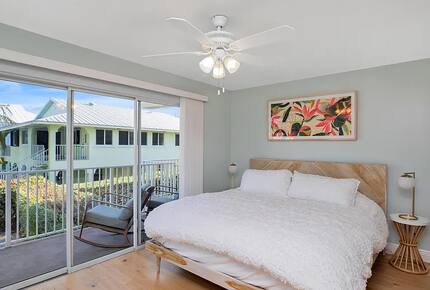 Main floor bedroom with balcony overlooking pool and canal