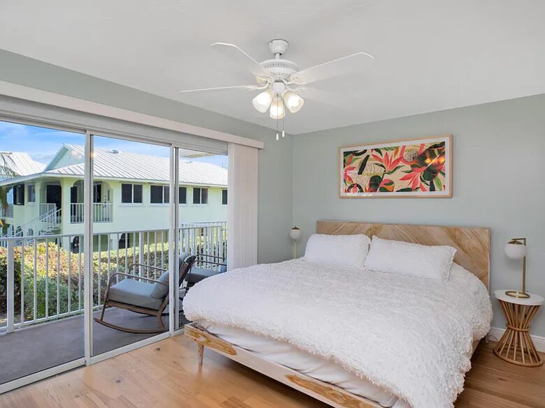 Main floor bedroom with balcony overlooking pool and canal