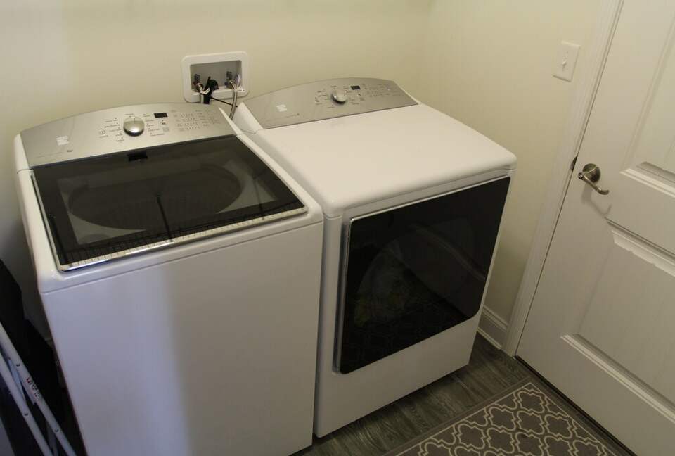 Large capacity washer and dryer in mudroom with sink