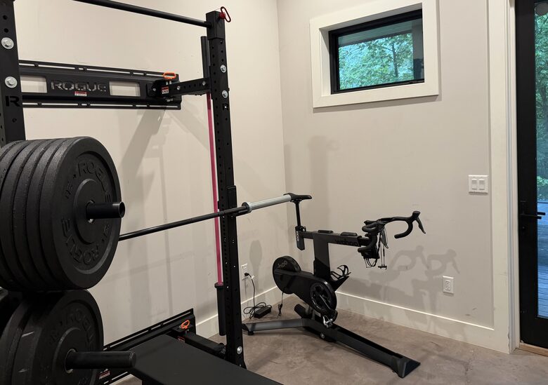 Full gym with Rogue rack, barbells, dumbbells and bike