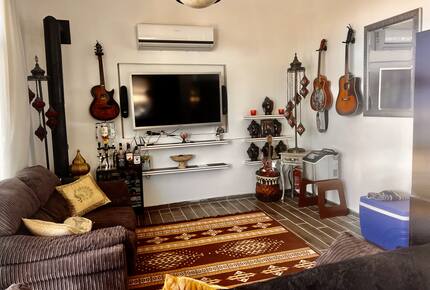 living room with TV and bed settee ice machine cooler and guitars