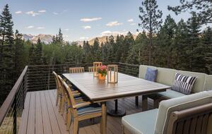Outdoor deck with railings, table & seating.