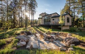 Stone fire pit with seating and the house in the distance.