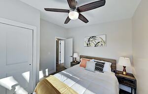 Guest room with queen bed, ceiling fan, and large closet