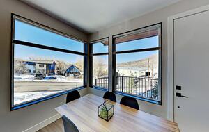 Main floor dining room table next to oversized windows