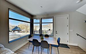 Main floor dining room table next to oversized windows