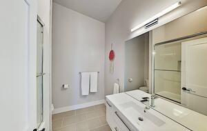 Full bathroom with beige floor tiles, white sink, and mirror