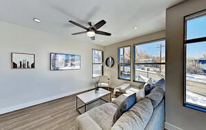 Main floor living room with beige sectional and wall art
