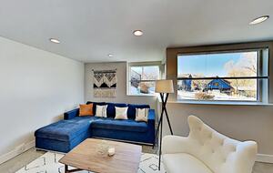 Bottom floor living room with blue sectional and cream sofa