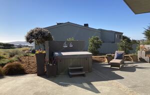 Hot tub and sun lounger at side patio.