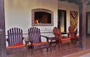 Home Exchange in Palm Springs, CA fireplace outside with lounge chairs