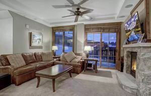 Living room with balcony and view of slope and peak 7