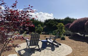 Front yard patio seating area with views of surrounding hills.