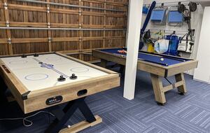 Gaming area adjacent to sports/beach accessories in garage.