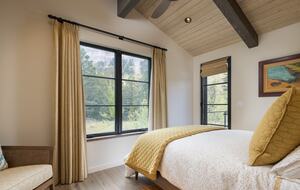Guest room with queen bed, large windows and door to deck.