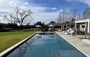 The pool and spa with lounge chairs and table seating.