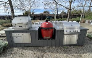 The BBQ area with pizza oven, Kamado Joe, and gas grill.