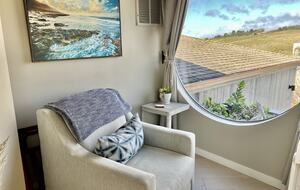 Reading area chair at landing with picturesque window.