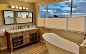 Upstairs primary en suite bathroom with dual vanity.