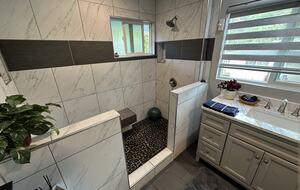 Smooth river rock shower with double head shower