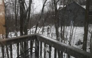 Winter photo showing the deck and nearest neighbor's home.
