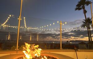Pool deck featuring fire pits overlooking the ocean