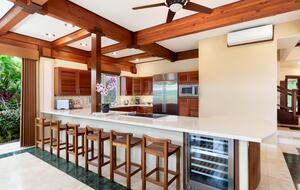 View of the kitchen with a wine fridge and bar stools