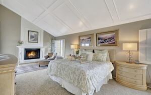 Primary bedroom with fireplace, sitting area and private balcony.