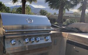 Large gas BBQ, entertainment center with barstools, fridge