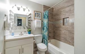 Guest bathroom with single sink and tub/shower combo