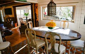 Formal dining area with windows looking out at forest