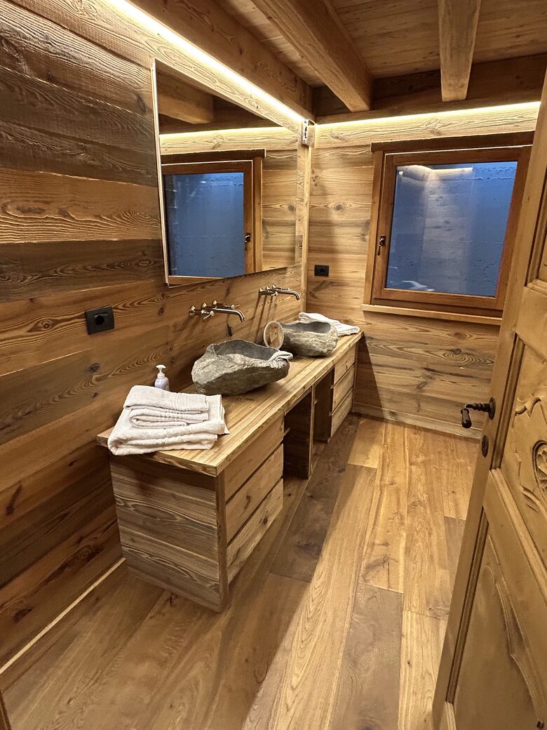 Guest bathroom with carved stone sinks and large shower