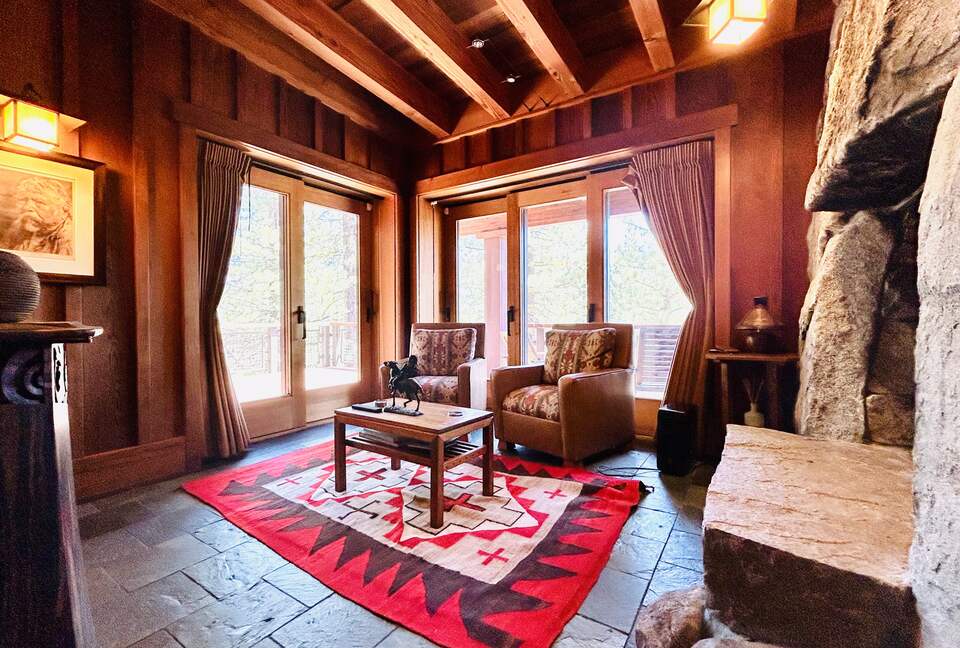 Native American art-filled den with fireplace, deck & views