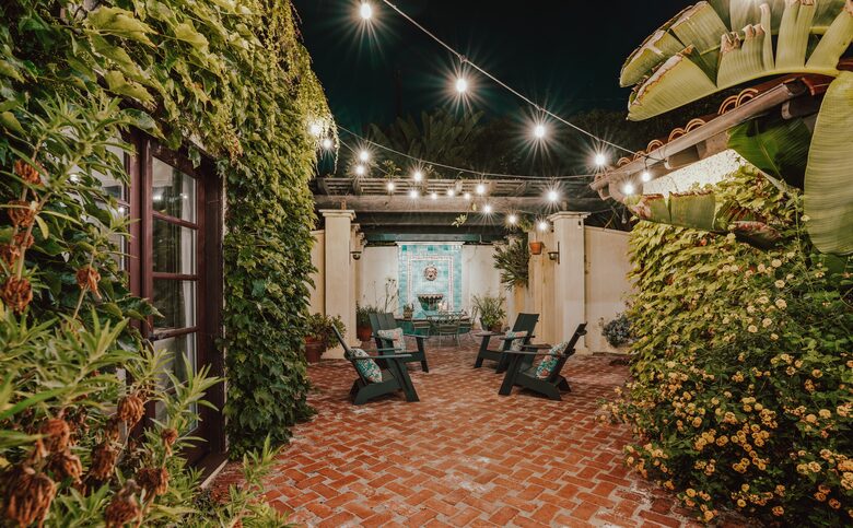 Back patio fountain, dining table, seating, string lights
