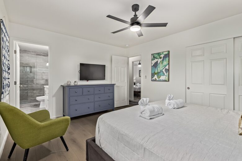 Master bedroom with dresser and smart TV