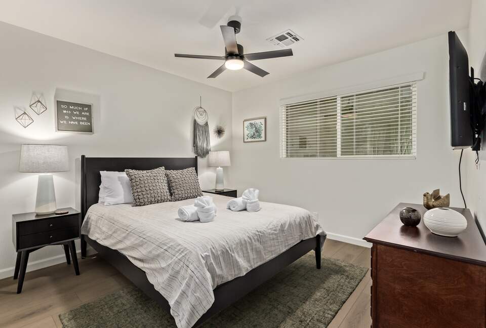Guest bedroom 1 with queen bed, dresser and smart TV