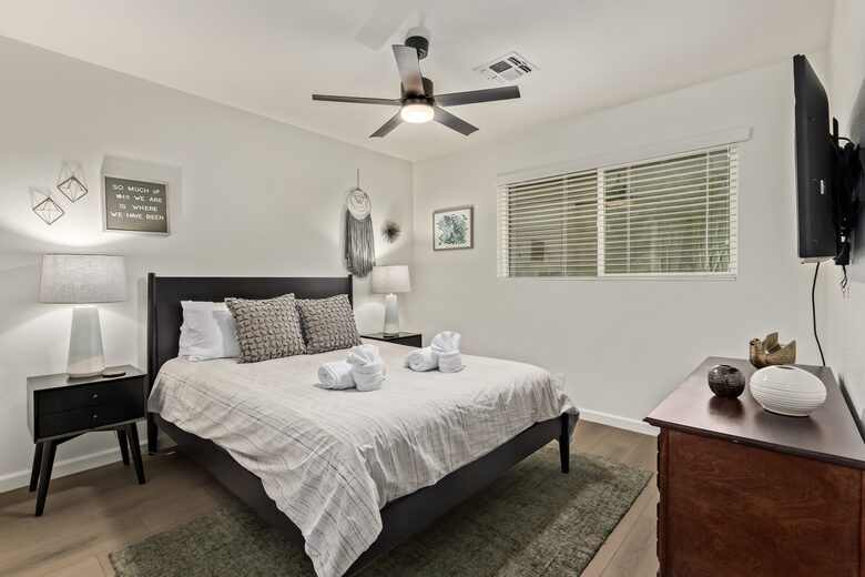 Guest bedroom 1 with queen bed, dresser and smart TV