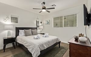 Guest bedroom 1 with queen bed, dresser and smart TV