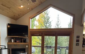 Great room with natural light and forest views