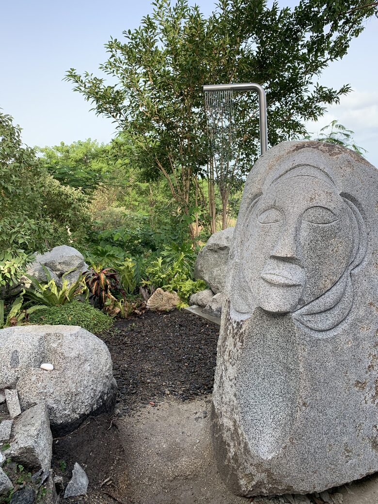 Outdoor shower with carving and surrounding jungle