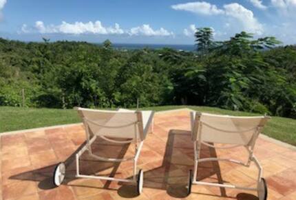 loungers by pool with a view of the ocean