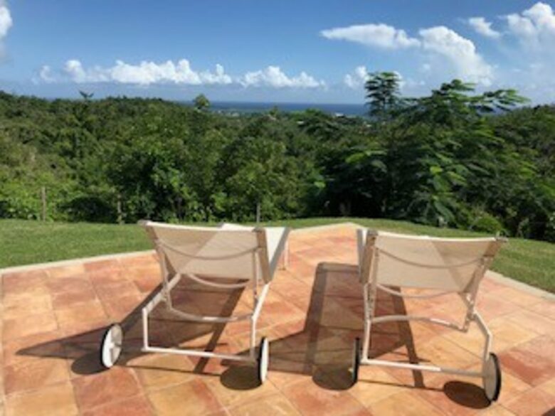 loungers by pool with a view of the ocean