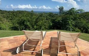 loungers by pool with a view of the ocean