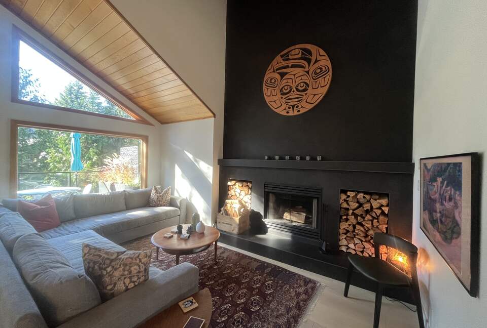 Living room with wood burning fireplace and 55” Frame TV