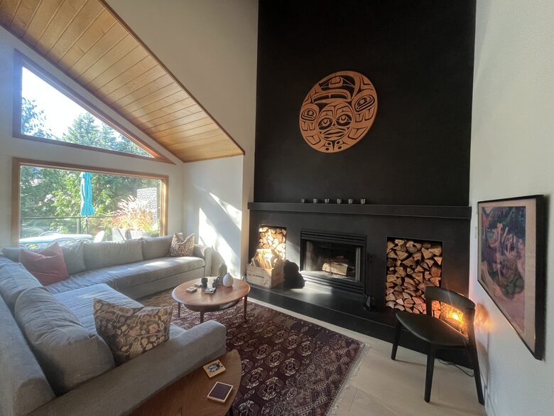 Living room with wood burning fireplace and 55” Frame TV