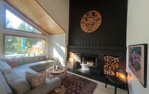 Living room with wood burning fireplace and 55” Frame TV